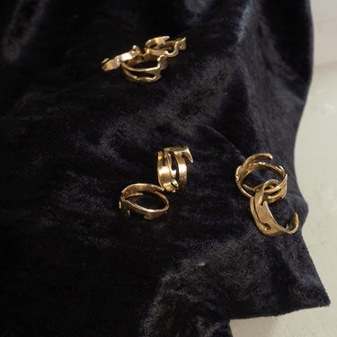 Gold toned landmass shaped ring on black velvet