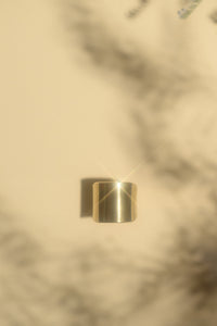 Gold saddle ring in a cream background