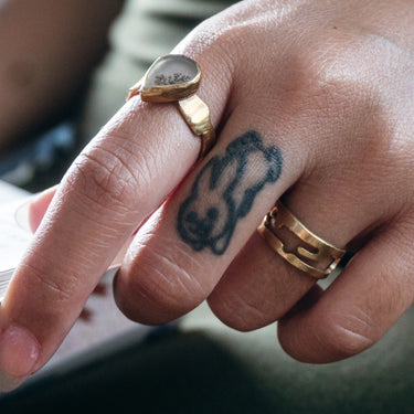 Gold landmass cut out ring band on a model's hand