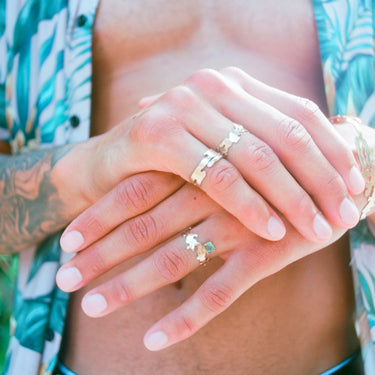 Gold toned landmass shaped ring on a black male hand