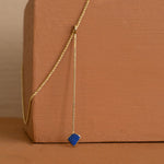 Load image into Gallery viewer, Lapis Lazuli Crystal Point Necklace against a burnt orange block
